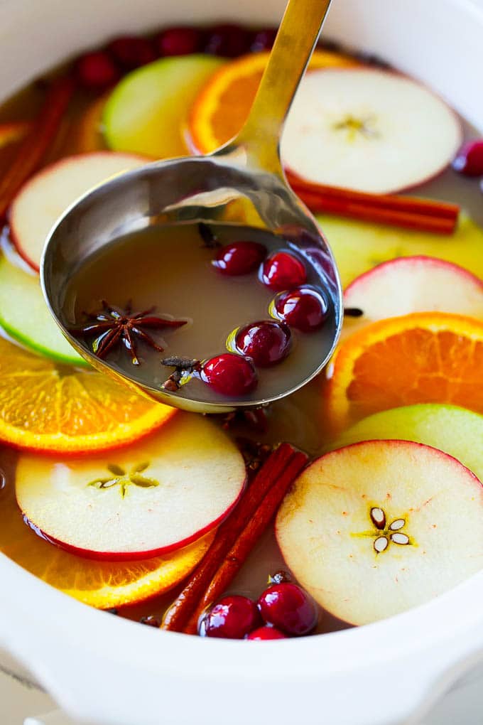 Slow Cooker Apple Cider | Mulled Apple Cider | Crockpot Apple Cider #cider #apple #applecider #drink #crockpot #slowcooker #sraye A ladle scooping out some warm mulled drink.