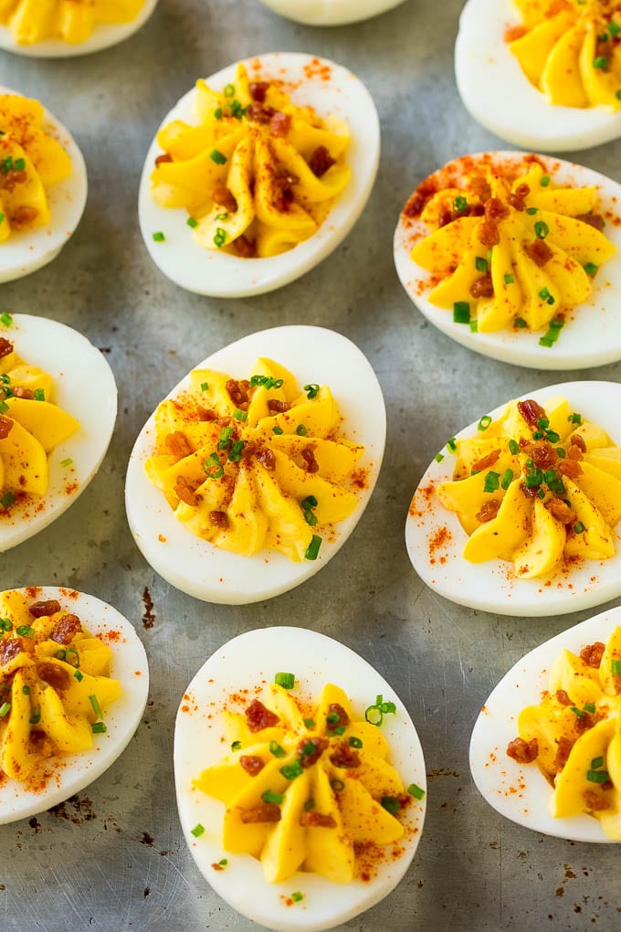 Bacon Deviled Eggs | Deviled Eggs Recipe #eggs #keto #lowcarb #bacon #appetizer #sraye Bacon deviled eggs topped with chives and paprika on a sheet pan.
