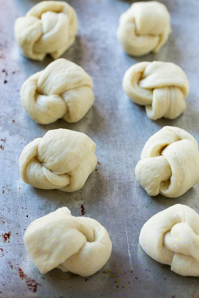 Garlic Knots Recipe | Garlic Rolls | Garlic Butter Rolls | Garlic Bread Recipe #garlic #garlicbread #garlicknots #breadsticks #sraye Pizza dough tied up and placed on a sheet pan.