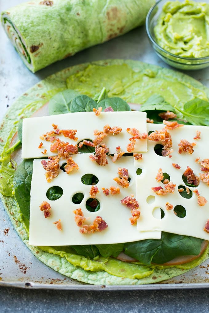 Turkey Roll Ups Recipe | Turkey Pinwheel Sandwiches | Turkey Roller Sandwiches #turkey #avocado #sandwich #lunch #appetizer #sraye A spinach tortilla layered with turkey, spinach, cheese and bacon.