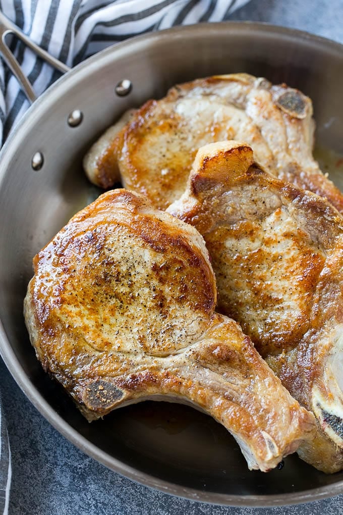 Brown Sugar Pork Chops Recipe | Bone In Pork Chops Recipe | Garlic Butter Pork Chops | Skillet Pork Chops #pork #porkchops #garlic #dinner #glutenfree #sraye Browned bone in pork chops in a frying pan.