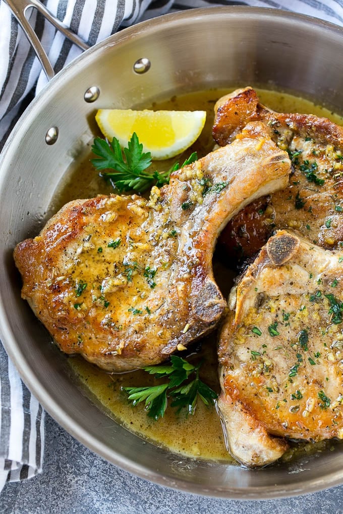 Brown Sugar Pork Chops Recipe | Bone In Pork Chops Recipe | Garlic Butter Pork Chops | Skillet Pork Chops #pork #porkchops #garlic #dinner #glutenfree #sraye Brown sugar pork chops with garlic, butter and herbs in a frying pan.
