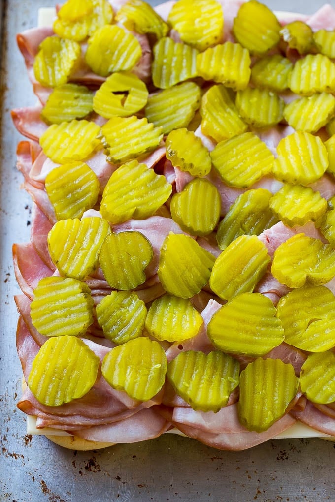 Cuban Sliders Recipe | Cuban Sandwich Recipe | Slider Sandwiches | Ham and Cheese Sliders #sliders #sandwiches #ham #cheese #appetizer #sraye Bread layered with cheese, ham and pickles.