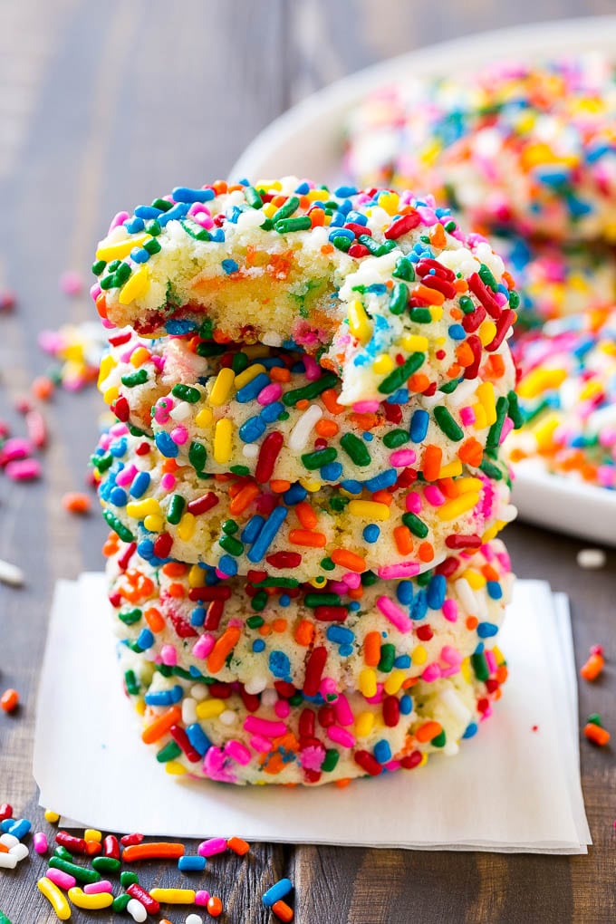 Funfetti Cookies Recipe | Funfetti Cake Mix Cookies | Sprinkle Cookies | Cake Mix Cookies #cookies #funfetti #sprinkles #dessert #sraye A stack of funfetti cookies with a bite taken out of one.