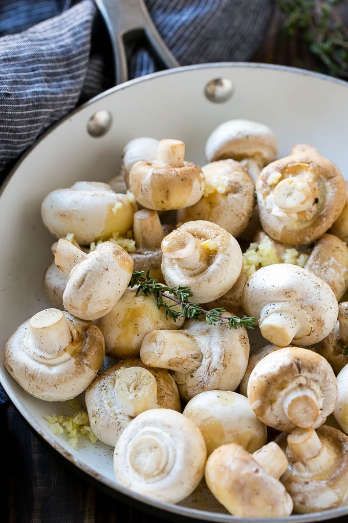 Garlic Mushrooms Recipe | Steakhouse Mushrooms | Sauteed Mushrooms | Garlic Butter Mushrooms | Mushroom Side Dish #mushrooms #butter #keto #lowcarb #dinner #sidedish #sraye Uncooked buttons with herbs and butter in a frying pan.