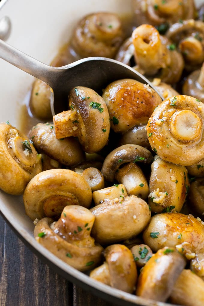 Garlic Mushrooms Recipe | Steakhouse Mushrooms | Sauteed Mushrooms | Garlic Butter Mushrooms | Mushroom Side Dish #mushrooms #butter #keto #lowcarb #dinner #sidedish #sraye A pan of sauteed garlic mushrooms with a serving spoon.