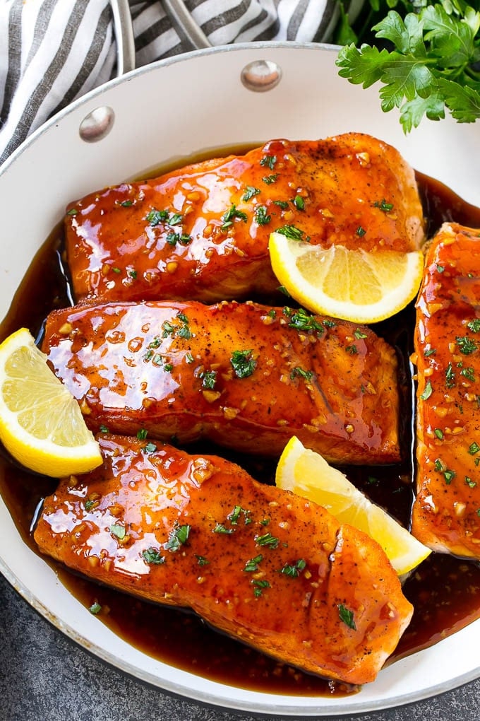 Honey Garlic Salmon Recipe | Asian Salmon Recipe | Healthy Salmon Recipe #salmon #fish #seafood #healthy #dinner #sraye A pan of honey garlic salmon topped with a savory sauce and garnished with parsley and lemon.