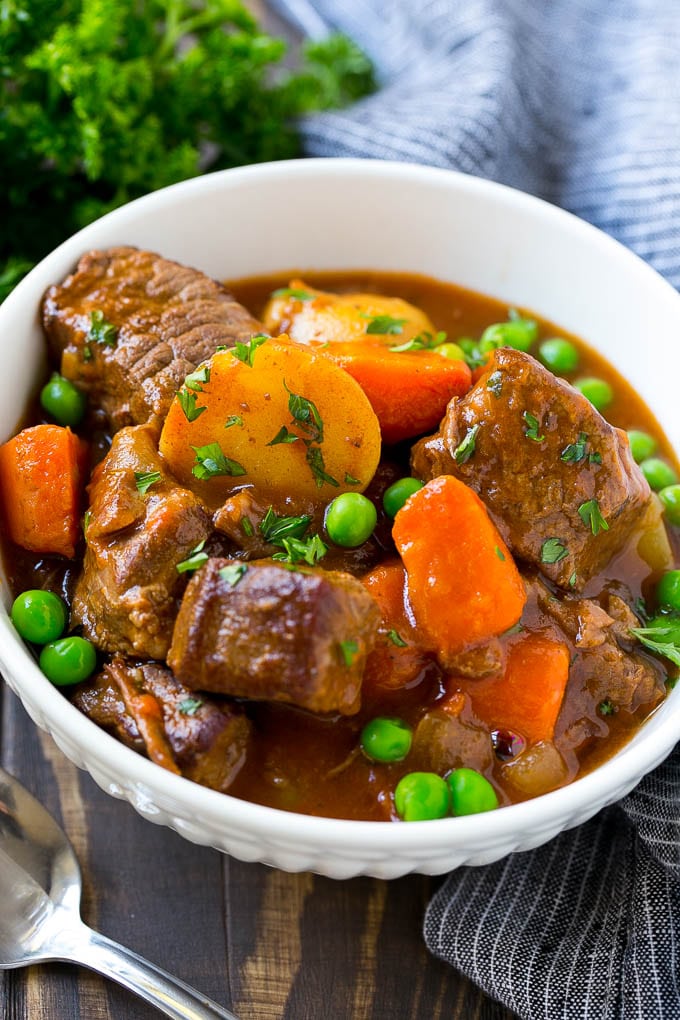 Slow Cooker Beef Stew Recipe | Beef and Potato Stew | Crock Pot Beef Stew | Easy Beef Stew #beef #beefstew #soup #slowcooker #crockpot #dinner #sraye A bowl of slow cooker beef stew with meat, carrots, potatoes and peas.