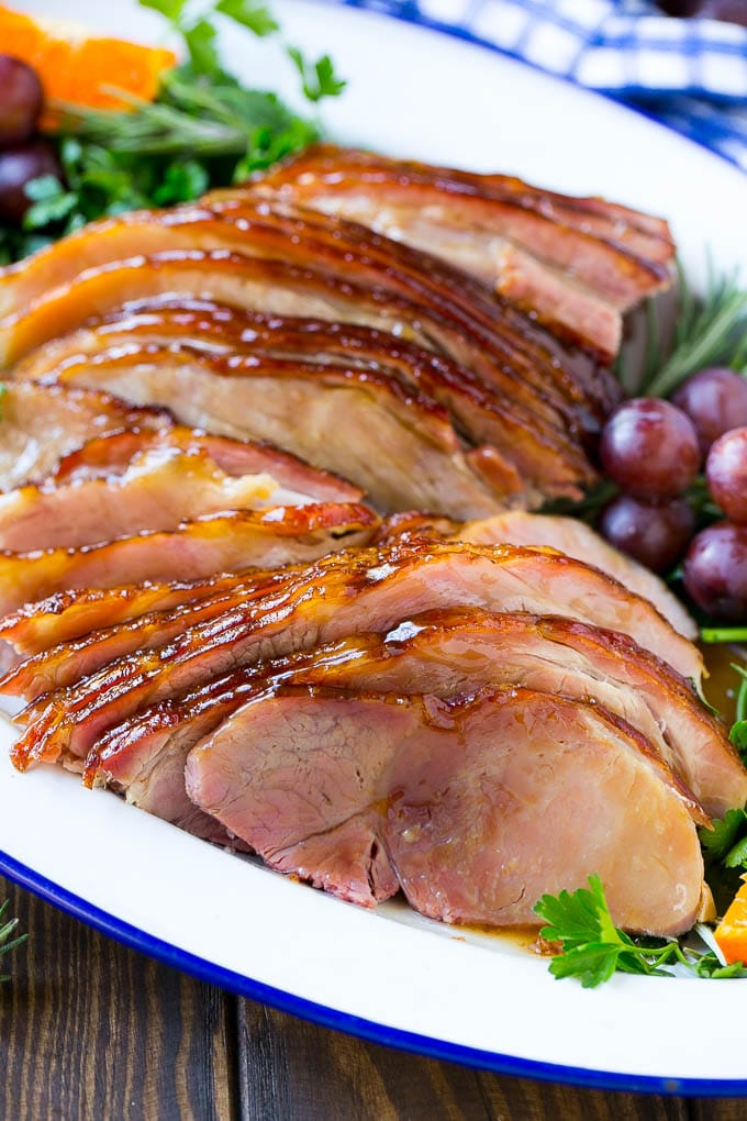 Coca Cola Ham | Coke Glazed Ham | Easter Ham | Christmas Ham | Holiday Ham Recipe #ham #easter #christmas #dinner #sraye A platter of sliced coca cola ham with herbs.