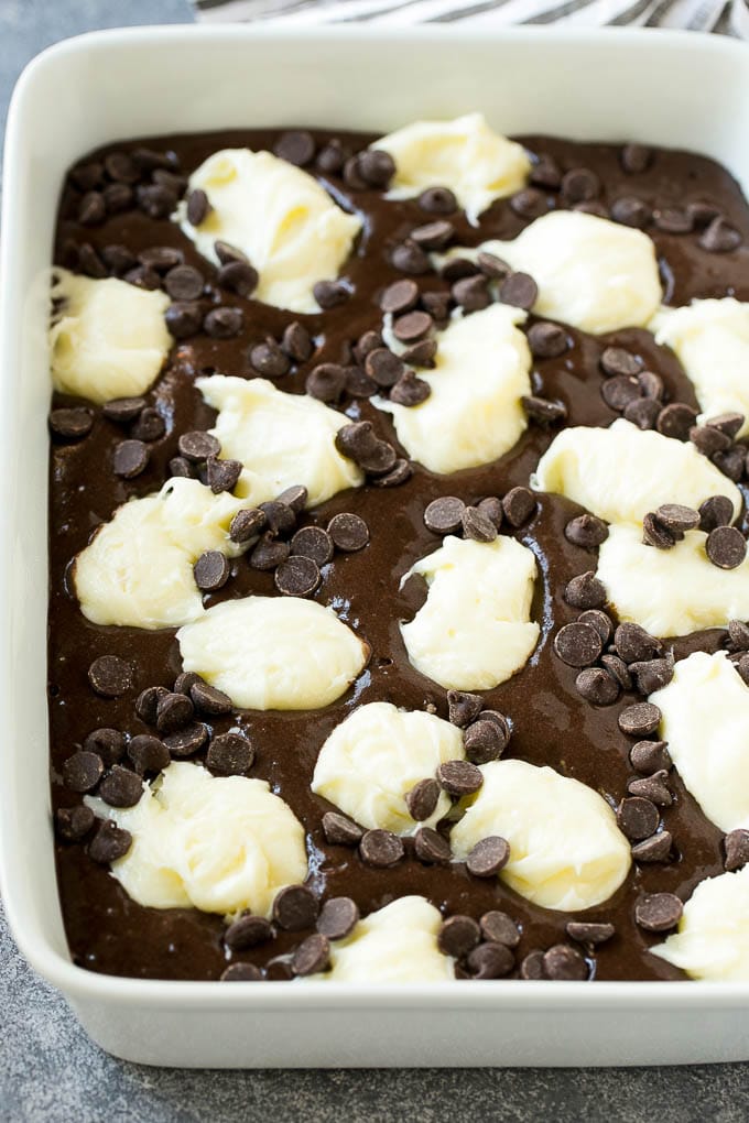 Earthquake Cake Recipe | Chocolate Cake Recipe | Chocolate Coconut Cake | Coconut Pecan Cake #cake #chocolate #coconut #pecans #dessert #chocolatecake #sraye Chocolate cake batter topped with dollops of sweetened cream cheese and chocolate chips.