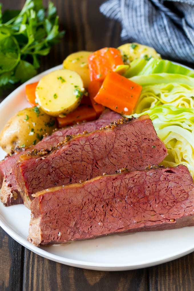 Slow Cooker Corned Beef Recipe | Crock Pot Corned Beef | Corned Beef and Cabbage #beef #cornedbeef #cabbage #potatoes #carrots #stpatricksday #irish #sraye Sliced slow cooker corned beef on a plate with carrots, potatoes and cabbage.
