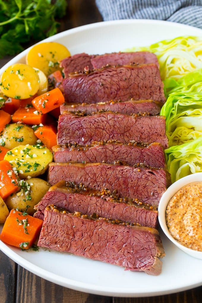 Slow Cooker Corned Beef Recipe | Crock Pot Corned Beef | Corned Beef and Cabbage #beef #cornedbeef #cabbage #potatoes #carrots #stpatricksday #irish #sraye A platter of slow cooker corned beef, cabbage wedges, potatoes and carrots.