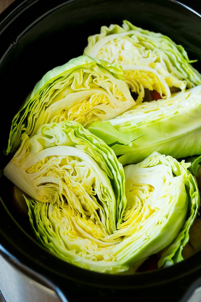 Slow Cooker Corned Beef Recipe | Crock Pot Corned Beef | Corned Beef and Cabbage #beef #cornedbeef #cabbage #potatoes #carrots #stpatricksday #irish #sraye Cabbage wedges inside a crock pot.