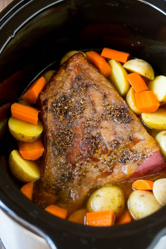 Slow Cooker Corned Beef Recipe | Crock Pot Corned Beef | Corned Beef and Cabbage #beef #cornedbeef #cabbage #potatoes #carrots #stpatricksday #irish #sraye A seasoned brisket with potatoes and carrots in a slow cooker.