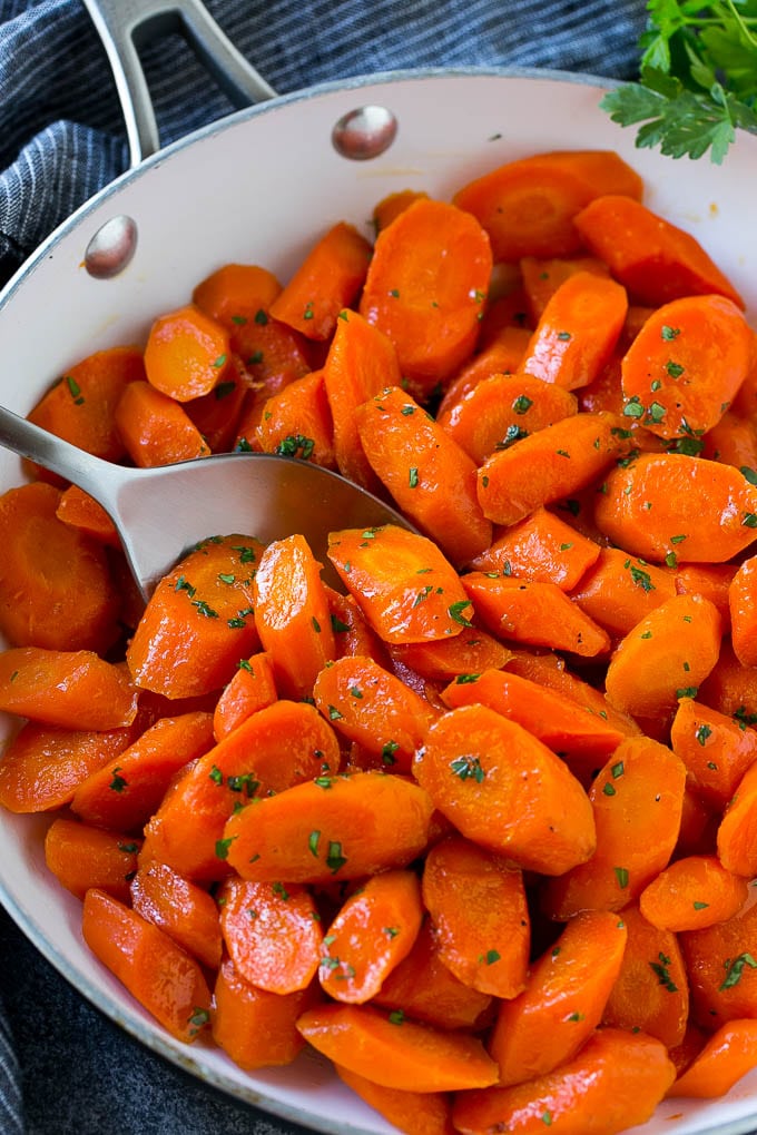 Candied Carrots Recipe | Carrot Side Dish | Brown Sugar Carrots | Glazed Carrots #carrots #brownsugar #sidedish #dinner #sraye Candied carrots in a pan with a serving spoon.