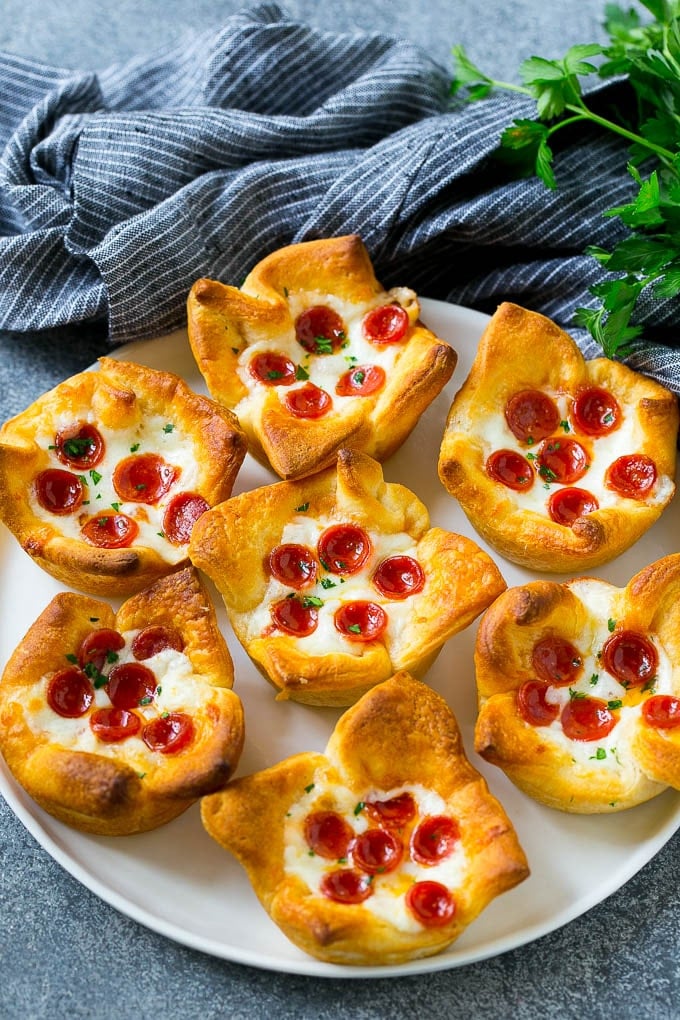 Pizza Muffins Recipe | Pizza Bites | Pizza Cups | Pizza Appetizer #pizza #appetizer #sraye Pizza muffins on a serving plate garnished with parsley.