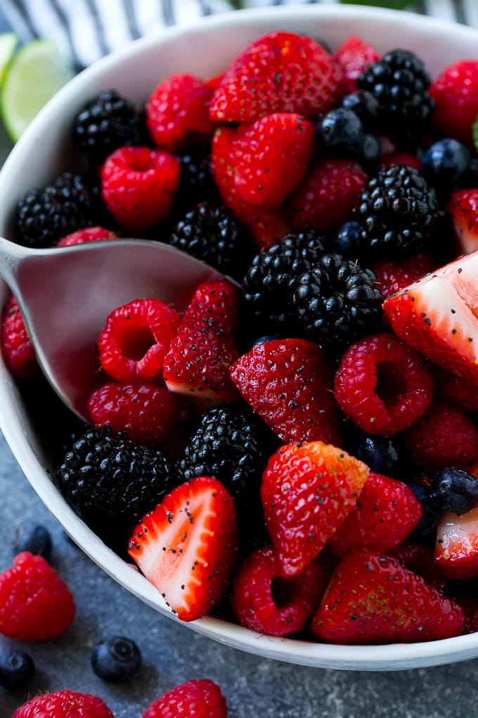Berry Fruit Salad Recipe | Berry Salad | Summer Berry Salad | Fruit Salad Recipe #berries #fruitsalad #sraye A bowl of berry fruit salad with a serving spoon in it.