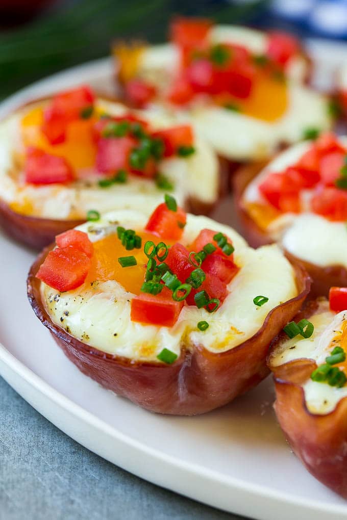 Ham and Egg Cups Recipe | Low Carb Breakfast | Ham and Eggs #ham #eggs #lowcarb #breakfast #sraye A plate of ham and egg cups topped with diced tomatoes and chives.