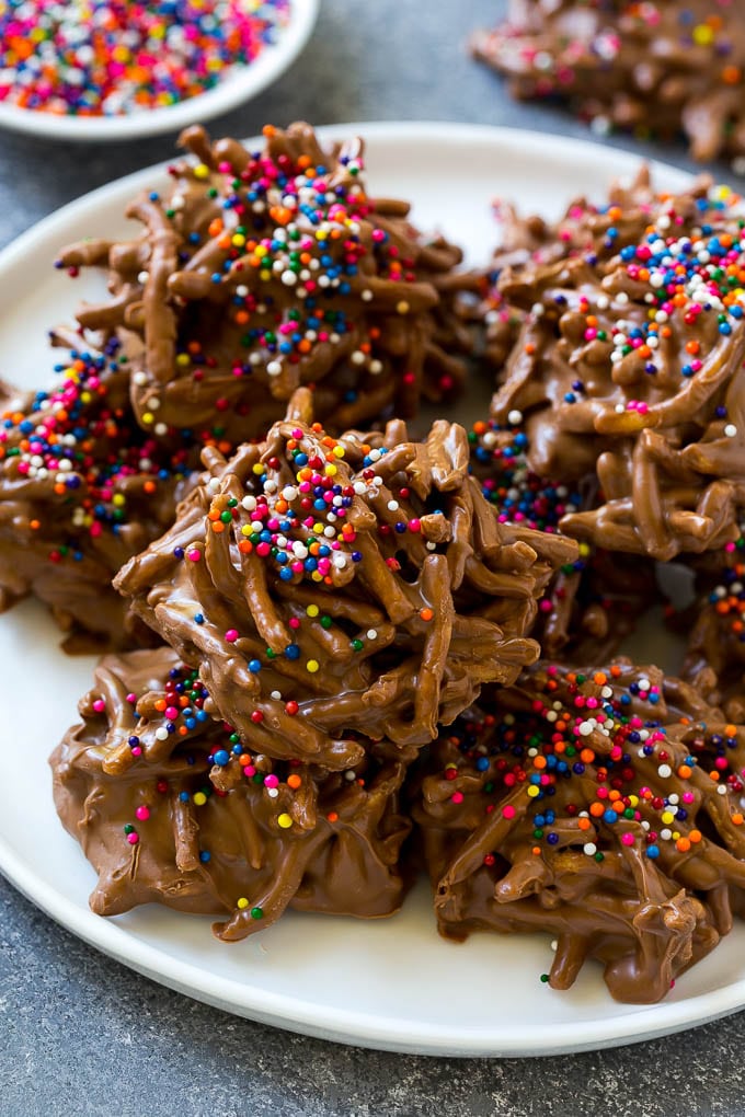 Haystack Cookies Recipe | No Bake Cookies | Chow Mein Noodle Cookies #nobakecookies #cookies #recipe #chocolate #sraye A plate of haystack cookies topped with rainbow sprinkles.