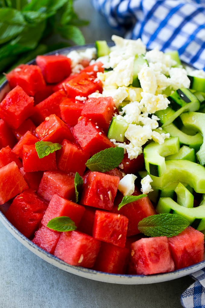 Watermelon Salad Recipe | Watermelon Feta Salad | Watermelon Cucumber Salad #watermelon #cucumber #salad #sraye A bowl of watermelon, cucumber, feta cheese and mint leaves drizzled with lime dressing.