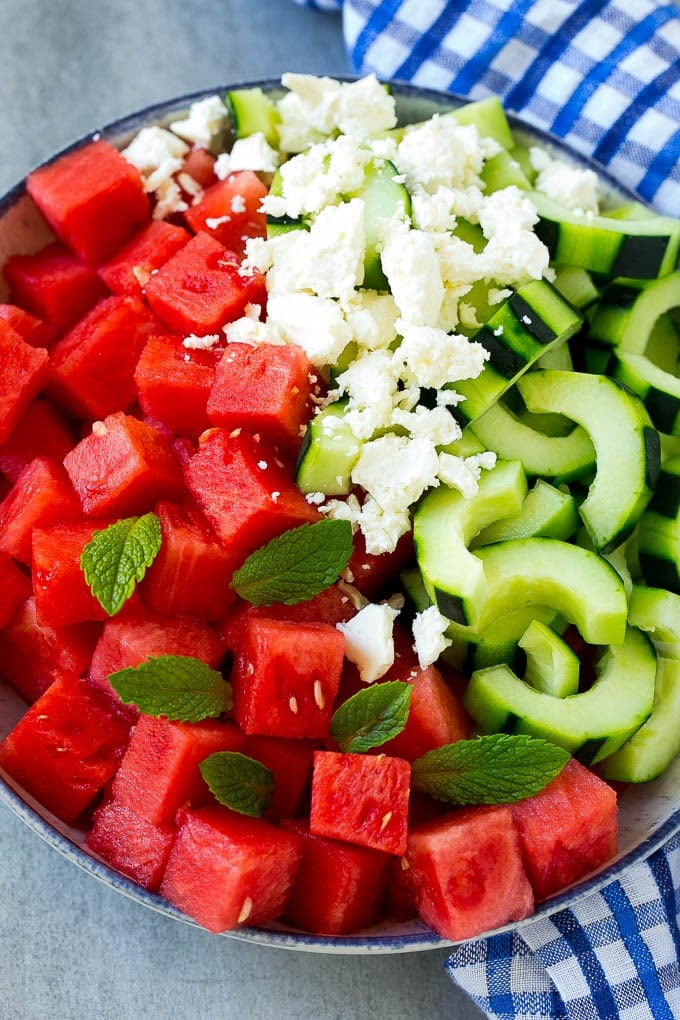 Watermelon Salad Recipe | Watermelon Feta Salad | Watermelon Cucumber Salad #watermelon #cucumber #salad #sraye A bowl of cubed watermelon, sliced cucumbers, feta cheese and mint leaves.