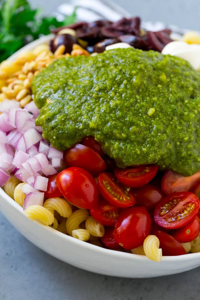 Pesto Pasta Salad | Italian Pasta Salad | Easy Pasta Salad #pasta #salad #pesto #olives #tomatoes #sraye Vegetables and corkscrew pasta topped with fresh pesto.
