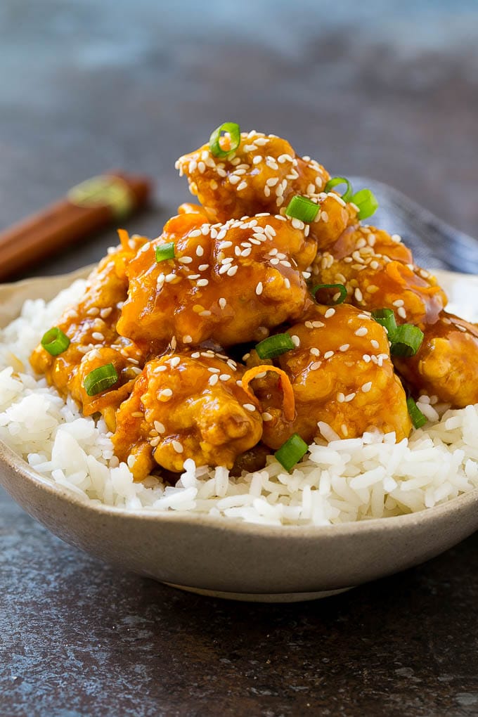 Orange Chicken Recipe | Chinese Orange Chicken | Panda Express Orange Chicken #orange #chicken #takeout #chinesefood #dinner #sraye A bowl of orange chicken served over steamed rice and topped with sesame seeds.