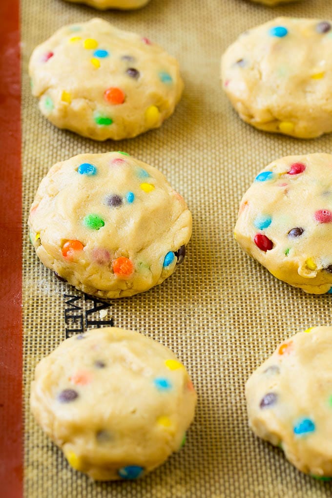 Oreo Stuffed Cookies Recipe | M&M's cookies | Stuffed Cookies #cookies #chocolate #oreos #dessert #baking #sraye Cookie dough balls stuffed with Oreo cookies on a sheet pan.