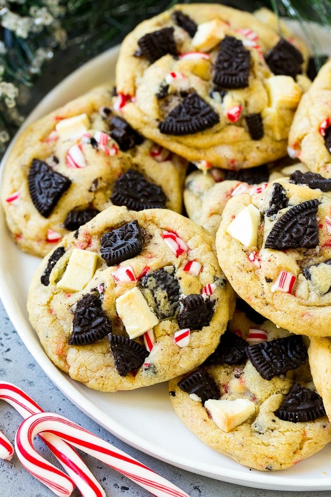 Oreo Peppermint Cookies Recipe | Candy Cane Cookies | Oreo Cookies #oreo #peppermint #cookies #baking #Christmas #sweets #sraye A plate of Oreo peppermint cookies filled with white chocolate and candy canes.
