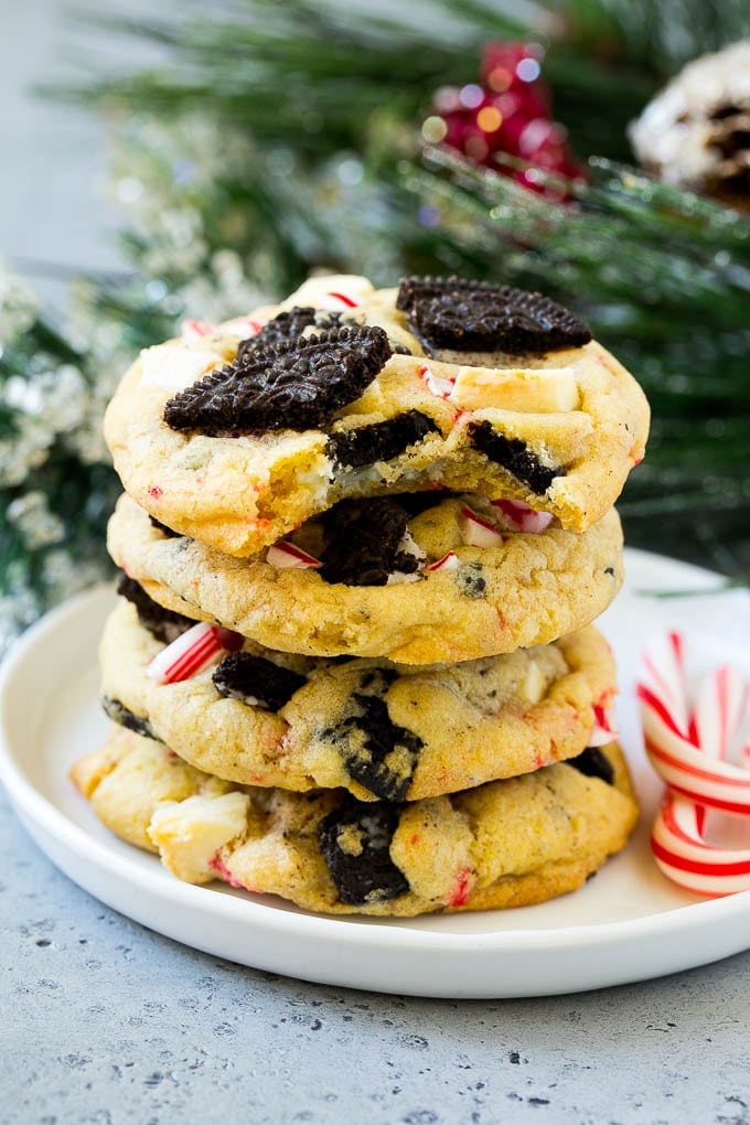 Oreo Peppermint Cookies Recipe | Candy Cane Cookies | Oreo Cookies #oreo #peppermint #cookies #baking #Christmas #sweets #sraye A stack of Oreo peppermint cookies on a plate, garnished with candy canes.