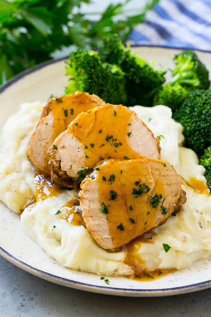 Slow Cooker Pork Tenderloin Recipe | Crock Pot Pork Tenderloin | Easy Pork Tenderloin #slowcooker #crockpot #pork #dinner #sraye Sliced slow cooker pork tenderloin served over mashed potatoes with broccoli.