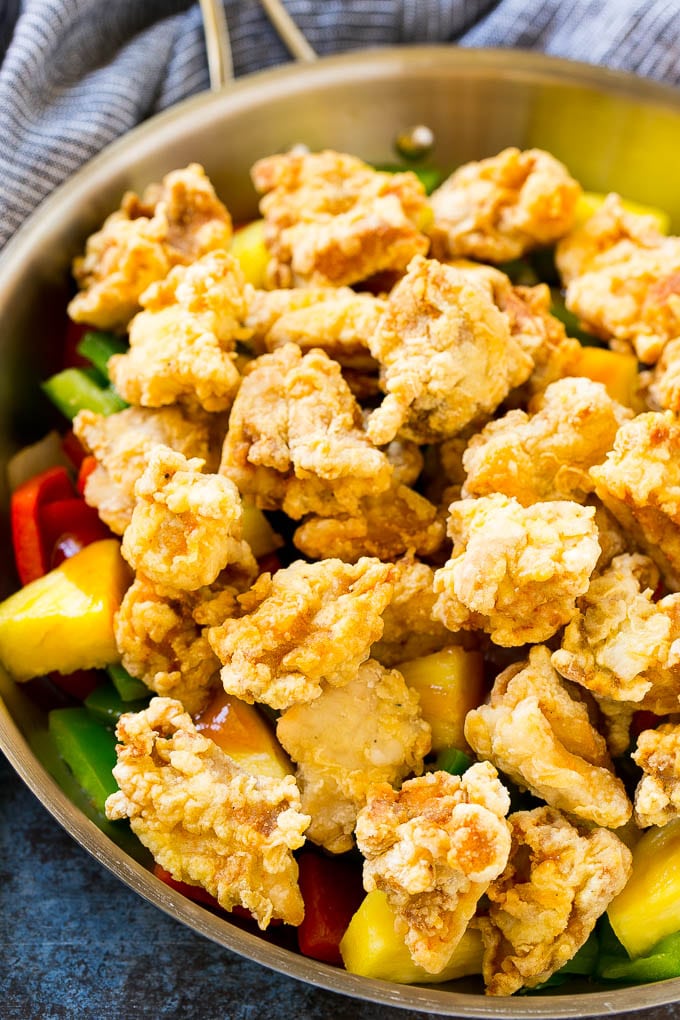 Sweet and Sour Chicken Recipe | Chinese Food Copycat Recipe | Chicken with Pineapple #chicken #chinesefood #pineapple #stirfry #takeout #dinner #sraye Fried chicken pieces in a pan with pineapple, peppers and onions.