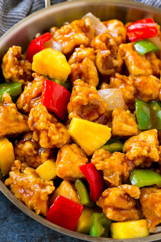 Sweet and Sour Chicken Recipe | Chinese Food Copycat Recipe | Chicken with Pineapple #chicken #chinesefood #pineapple #stirfry #takeout #dinner #sraye A frying pan of sweet and sour chicken with crispy chicken, pineapple, bell peppers and onions.