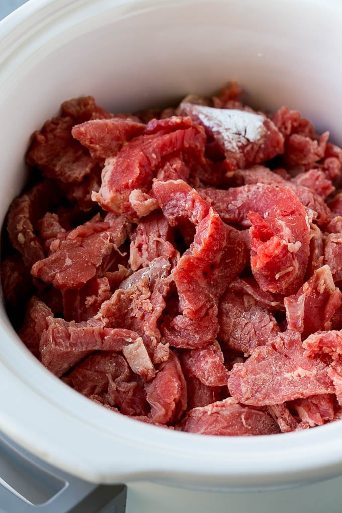 Slow Cooker Korean Beef Recipe | Korean Beef | Flank Steak Recipe #dinner #beef #slowcooker #crockpot #asian #sraye Flank steak strips tossed in cornstarch inside a slow cooker.