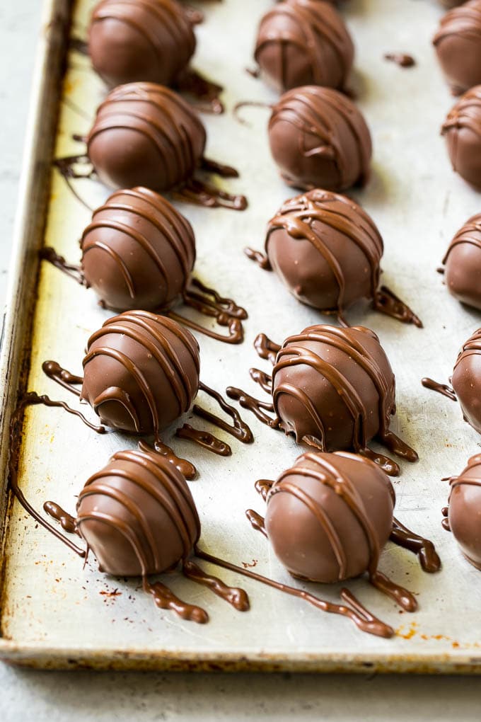 Chocolate Covered Cherries Recipe | Cherry Cordials | Cherry Candy #chocolate #candy #dessert #cherry #sweets #sraye Chocolate covered cherries on a sheet pan with a chocolate drizzle on top.