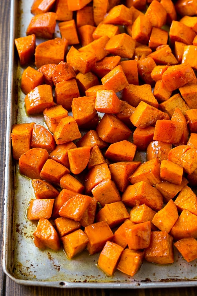 Maple Roasted Sweet Potatoes Recipe | Easy Sweet Potatoes | Baked Sweet Potatoes | Sweet Potato Side Dish #sweetpotatoes #cinnamon #maple #butter #fall #sidedish #dinner #sraye A sheet pan of roasted sweet potatoes.