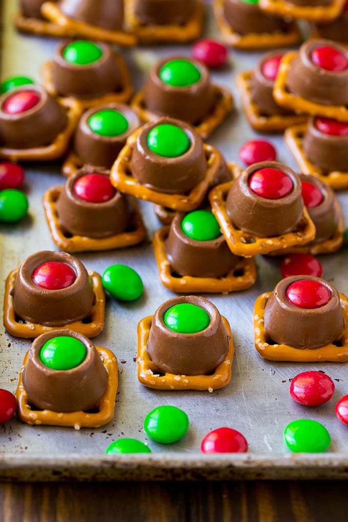 Rolo Pretzels Recipe | Chocolate Pretzels | Caramel Pretzels | Holiday Candy #christmas #baking #dessert #candy #chocolate #caramel #pretzels #sraye Rolo pretzels on a baking sheet topped with red and green M&M's.