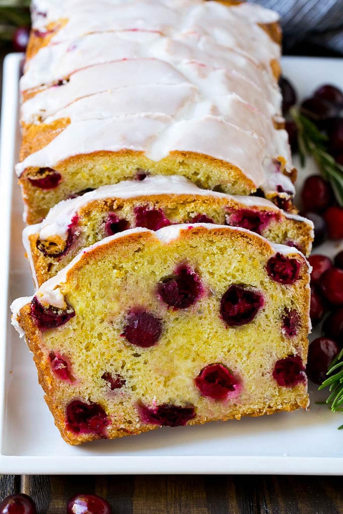 Cranberry Bread Recipe | Cranberry Loaf | Cranberry Orange Bread #cranberry #bread #baking #dessert #fall #sraye Slices of cranberry bread topped with orange glaze.
