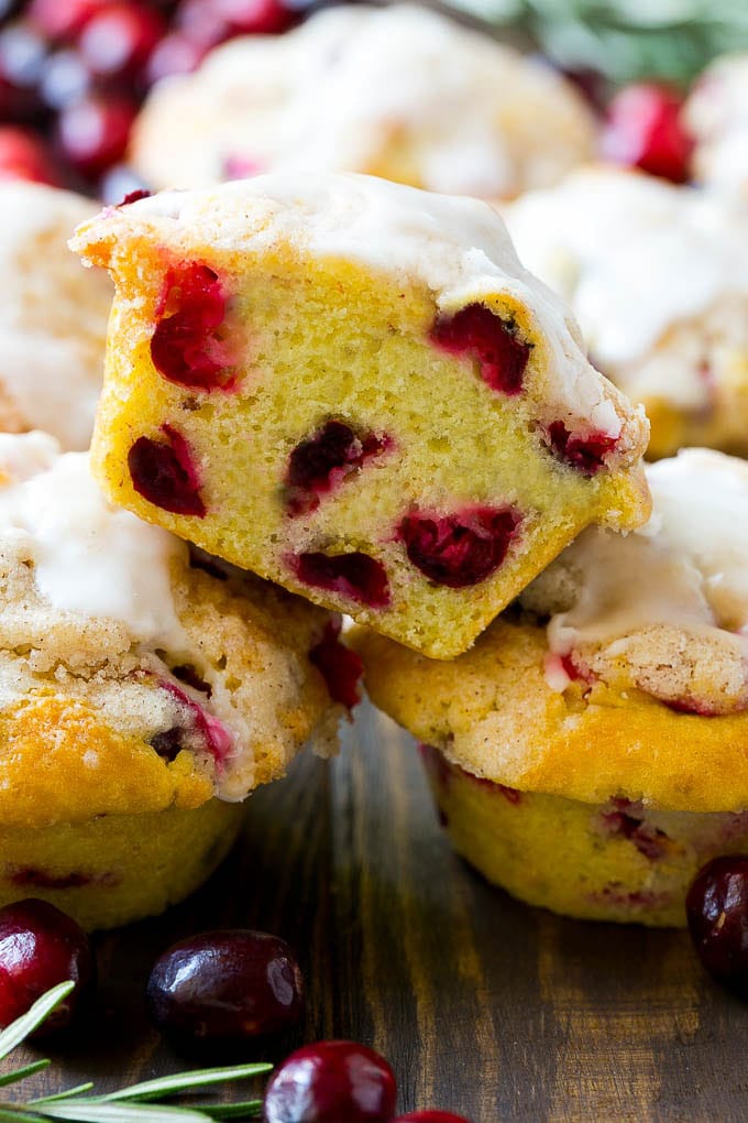 Cranberry Muffins Recipe | Cranberry Orange Muffins #cranberry #muffins #orange #fall #dessert #sraye A stack of cranberry muffins with one muffin cut in half.