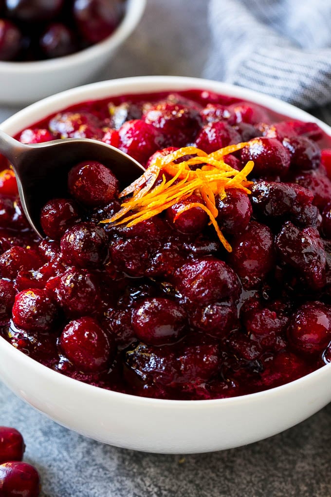 Cranberry Orange Sauce Recipe | Homemade Cranberry Sauce | Fresh Cranberry Sauce #cranberry #orange #fall #thanksgiving #sauce #dinner #sraye A serving spoon in a bowl of cranberry orange sauce.