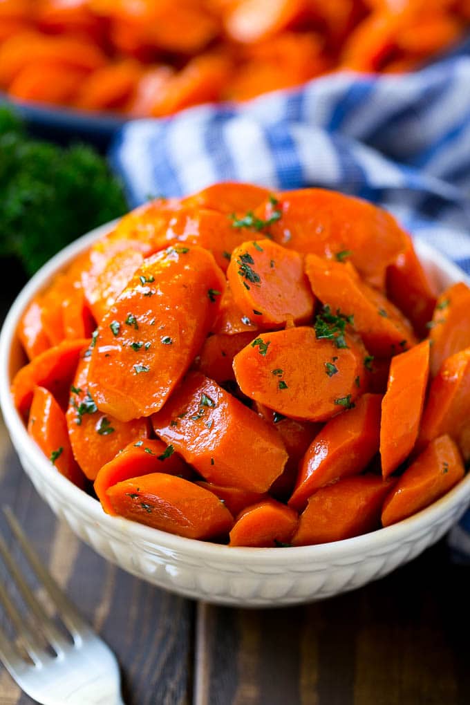 Glazed Carrots Recipe | Brown Sugar Carrots | Carrot Side Dish #carrots #brownsugar #sidedish #glutenfree #thanksgiving #fall #dinner #sraye A bowl of glazed carrots topped with parsley.