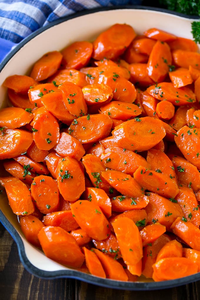 Glazed Carrots Recipe | Brown Sugar Carrots | Carrot Side Dish #carrots #brownsugar #sidedish #glutenfree #thanksgiving #fall #dinner #sraye A skillet of glazed carrots with brown sugar and butter sauce.