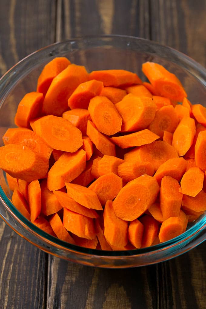 Glazed Carrots Recipe | Brown Sugar Carrots | Carrot Side Dish #carrots #brownsugar #sidedish #glutenfree #thanksgiving #fall #dinner #sraye A bowl of peeled and sliced carrots.