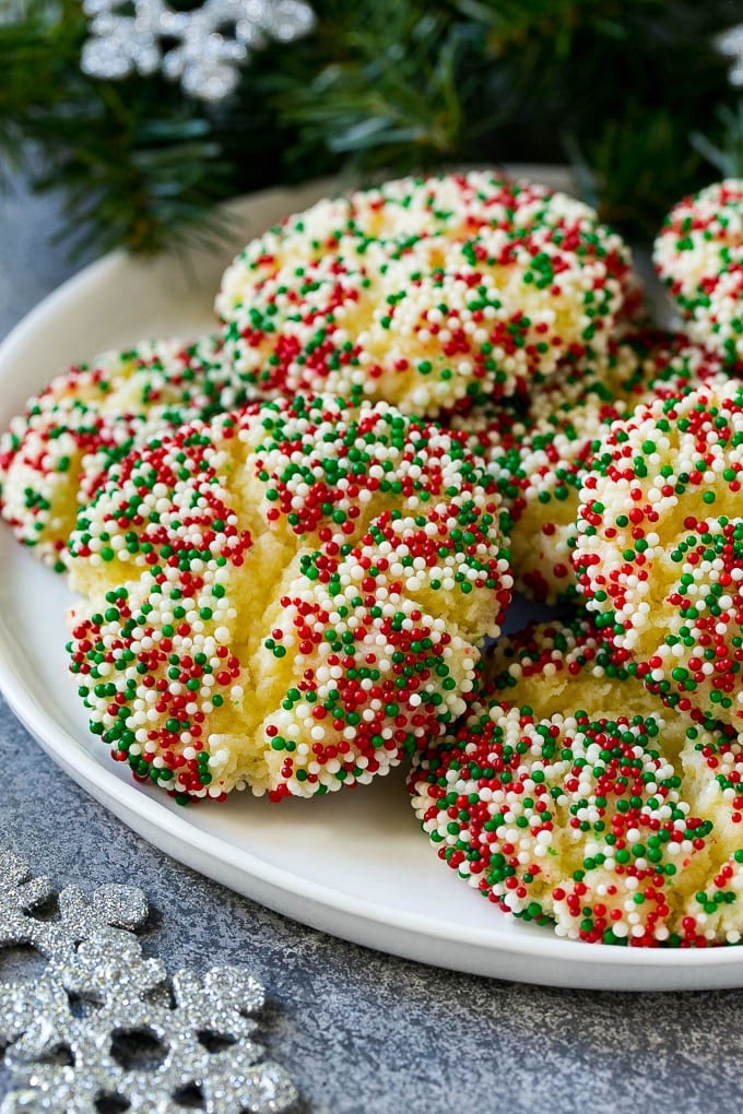 Gooey Butter Cookies Recipe | Cake Mix Cookies | Sprinkle Cookies | Christmas Cookies #cookies #butter #sprinkles #christmas #dessert #baking #sraye A plate of gooey butter cookies covered in holiday sprinkles.