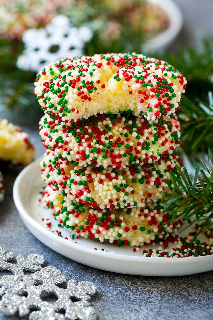 Gooey Butter Cookies Recipe | Cake Mix Cookies | Sprinkle Cookies | Christmas Cookies #cookies #butter #sprinkles #christmas #dessert #baking #sraye A stack of gooey butter cookies with a bite taken out of one.