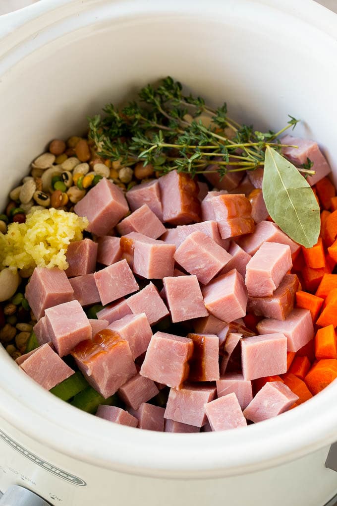 Ham and Bean Soup Recipe | Slow Cooker Ham and Bean Soup | Crockpot Ham and Bean Soup | Leftover Ham Recipe #ham #beans #soup #slowcooker #crockpot #dinner #sraye Vegetables, pork, herbs and garlic in the slow cooker.