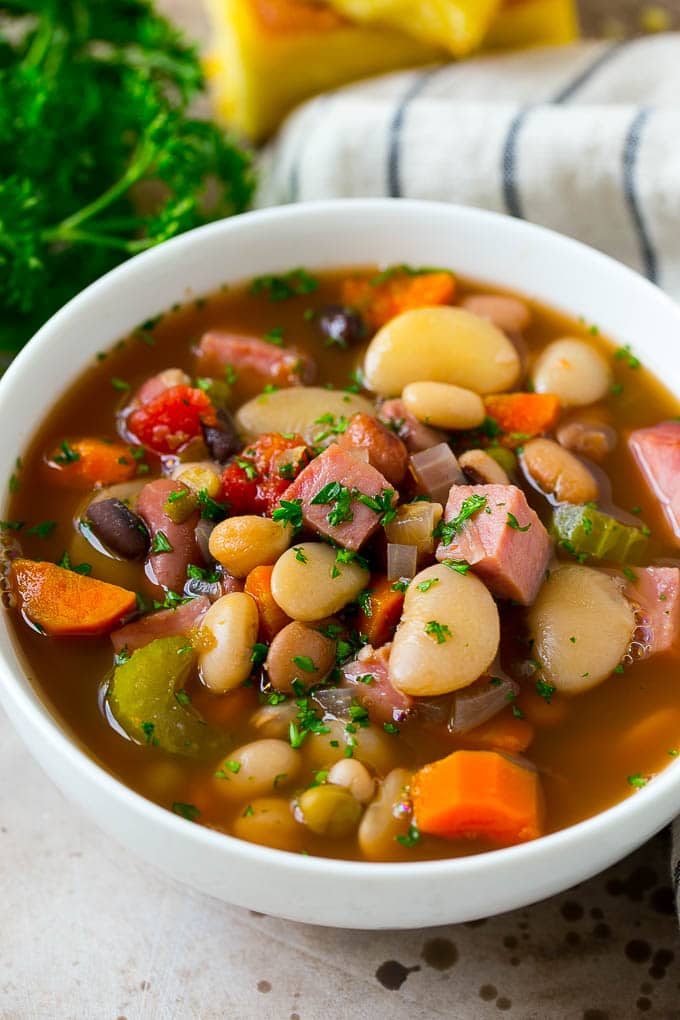 Ham and Bean Soup Recipe | Slow Cooker Ham and Bean Soup | Crockpot Ham and Bean Soup | Leftover Ham Recipe #ham #beans #soup #slowcooker #crockpot #dinner #sraye A bowl of ham and bean soup made with dried beans, ham and vegetables, then topped with fresh parsley.