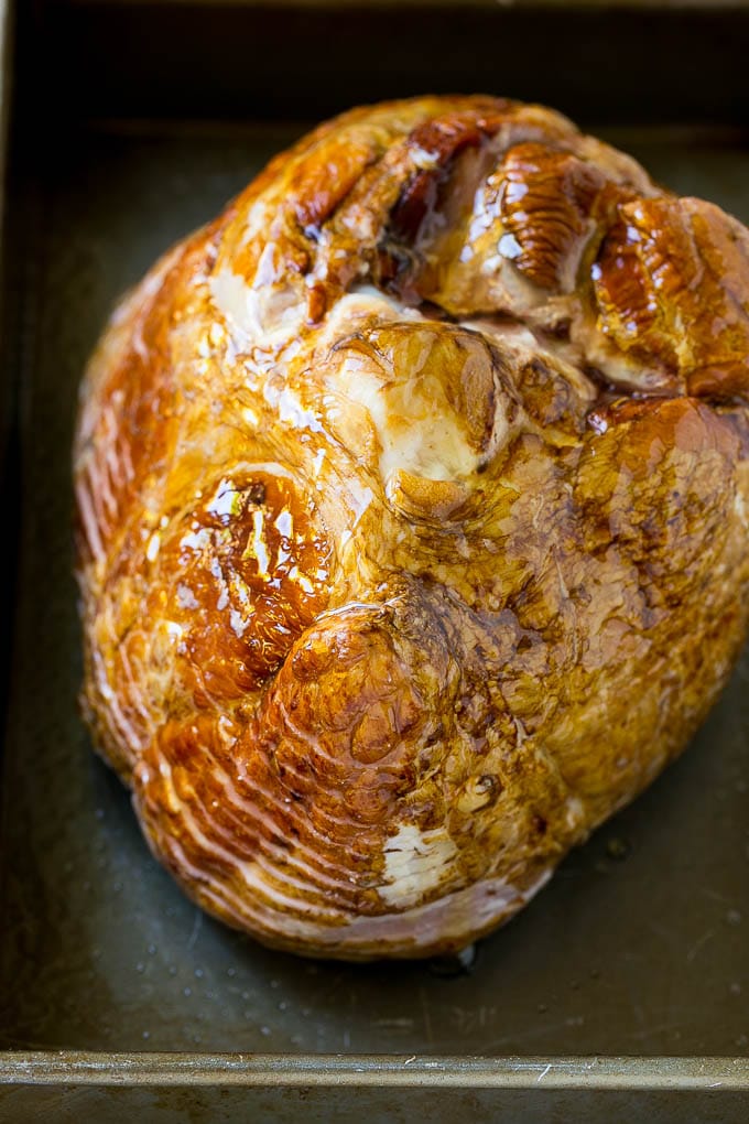 Honey Baked Ham Recipe | Glazed Ham | Holiday Ham #ham #dinner #sraye #christmas #thanksgiving #easter A honey coated ham, face down, in a baking dish.