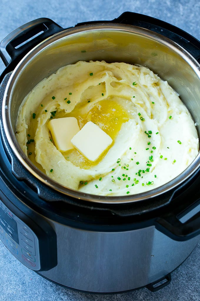 Instant Pot Mashed Potatoes Recipe | Pressure Cooker Mashed Potatoes | Easy Mashed Potatoes #potatoes #sidedish #instantpot #thanksgiving #dinner #sraye Instant Pot mashed potatoes with butter and chives inside a pressure cooker.
