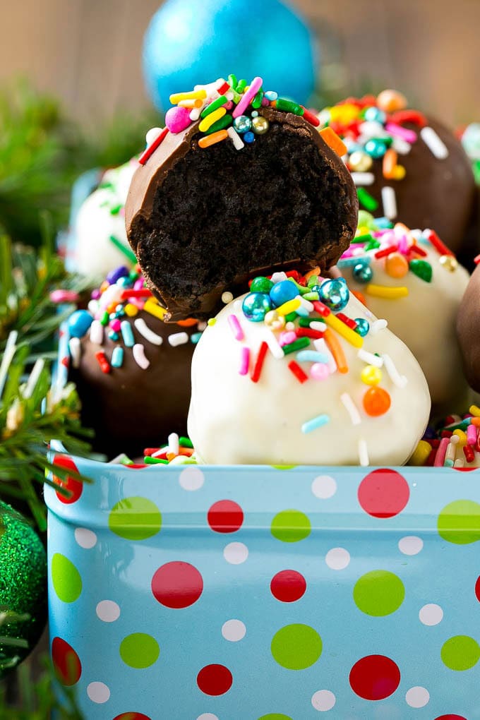 Oreo Balls Recipe | Oreo Truffles | Homemade Candy #truffles #candy #oreos #chocolate #sprinkles #dessert #christmas #sraye A cross section of an Oreo ball inside a holiday gift tin.